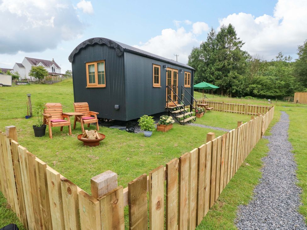 An outdoor area with a shepherd hut and seating at Shepherd Hut 1 Llandeilo
