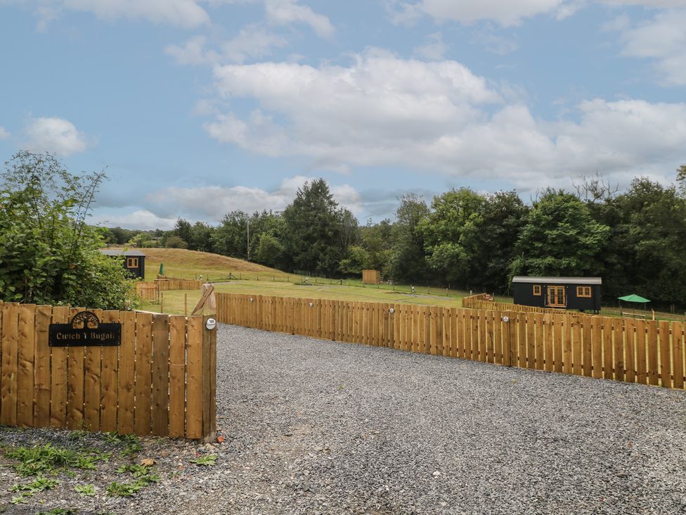 An outdoor area with gravel and wooden fence at Cwtch Y Bugail 1 Near Llandeilo