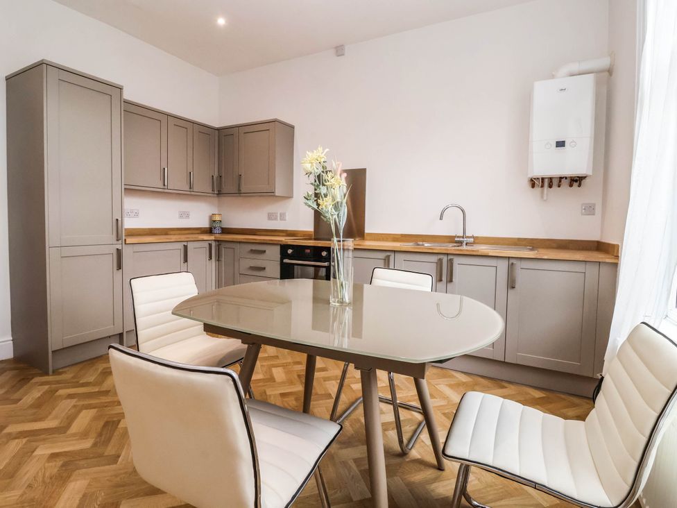 A kitchen with cabinets, table, and chairs at 154 Queen Street in Withernsea