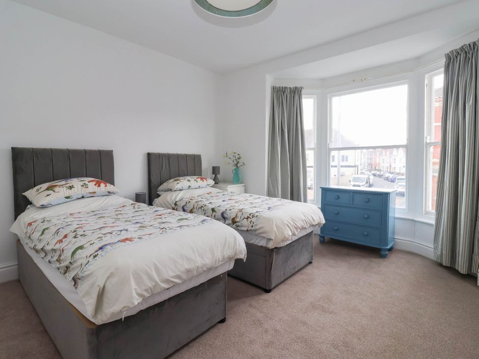 A bedroom with two beds and a blue dresser at 154 Queen Street in Withernsea