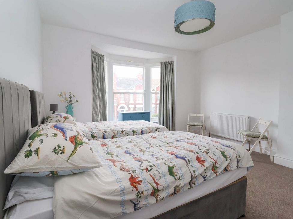 A bedroom with two beds and a window at 154 Queen Street in Withernsea