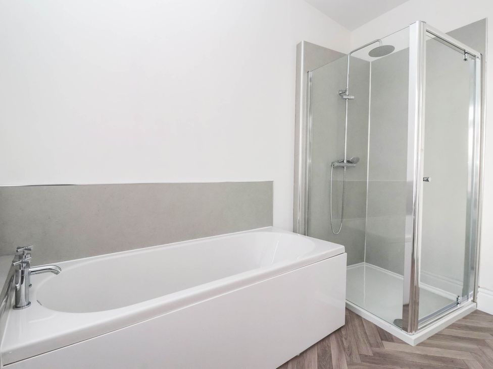 A bathroom with a bathtub and shower at 154 Queen Street in Withernsea