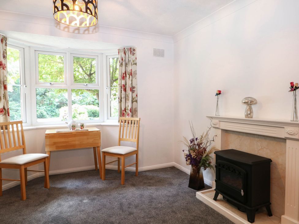 A living room with a table and chairs near windows at 44 Court Road in Lewes, Sussex