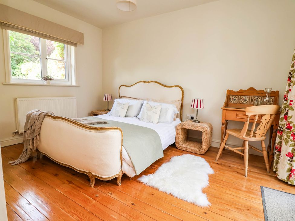A bedroom with a bed, desk, and window at Lyneal Cottage in Ellesmere