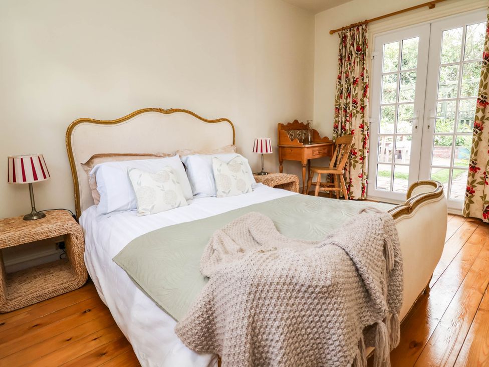 A bedroom with a bed and side tables at Lyneal Cottage in Ellesmere