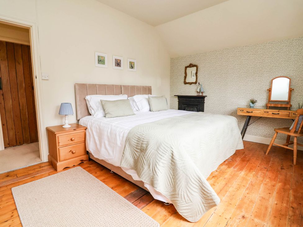 A bedroom with a bed and desk at Lyneal Cottage in Ellesmere