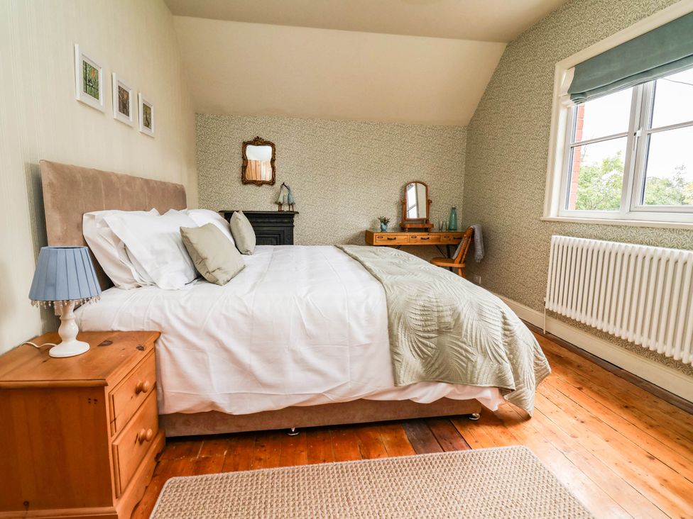 A bedroom with a bed and a dressing table at Lyneal Cottage in Ellesmere