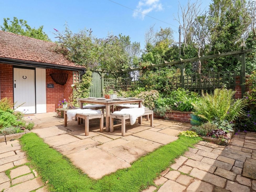 A garden with a table and chairs at Lyneal Cottage in Ellesmere