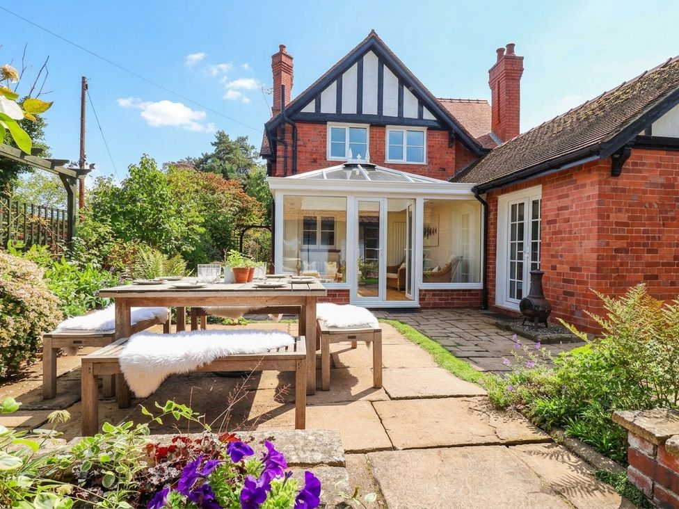 A garden with a table and chairs at Lyneal Cottage in Ellesmere