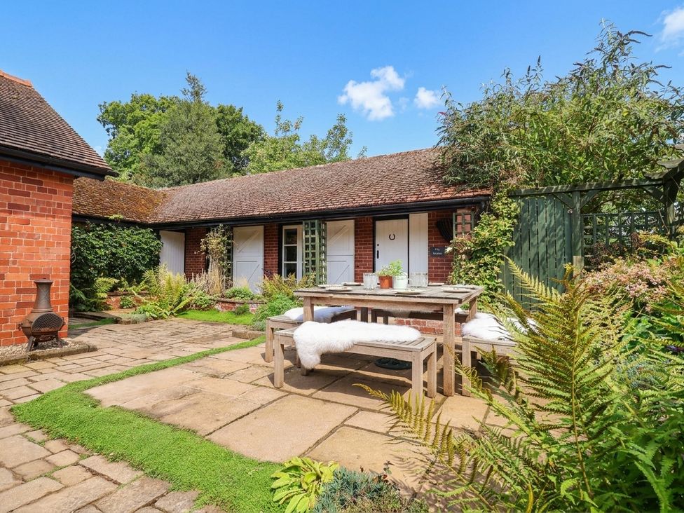 A garden with a table and chairs at Lyneal Cottage in Ellesmere