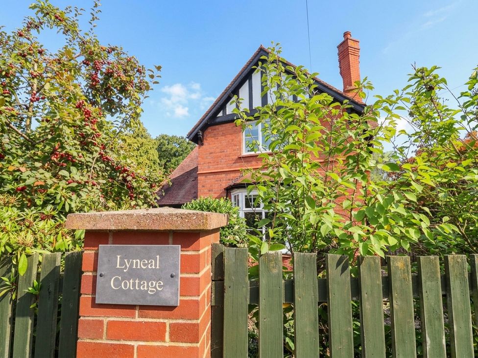 A cottage with a garden and fence at Lyneal Cottage in Ellesmere