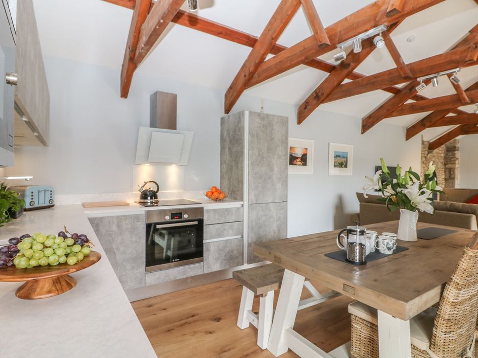 A kitchen with a dining table and chairs at Helford near Treverva near Constantine