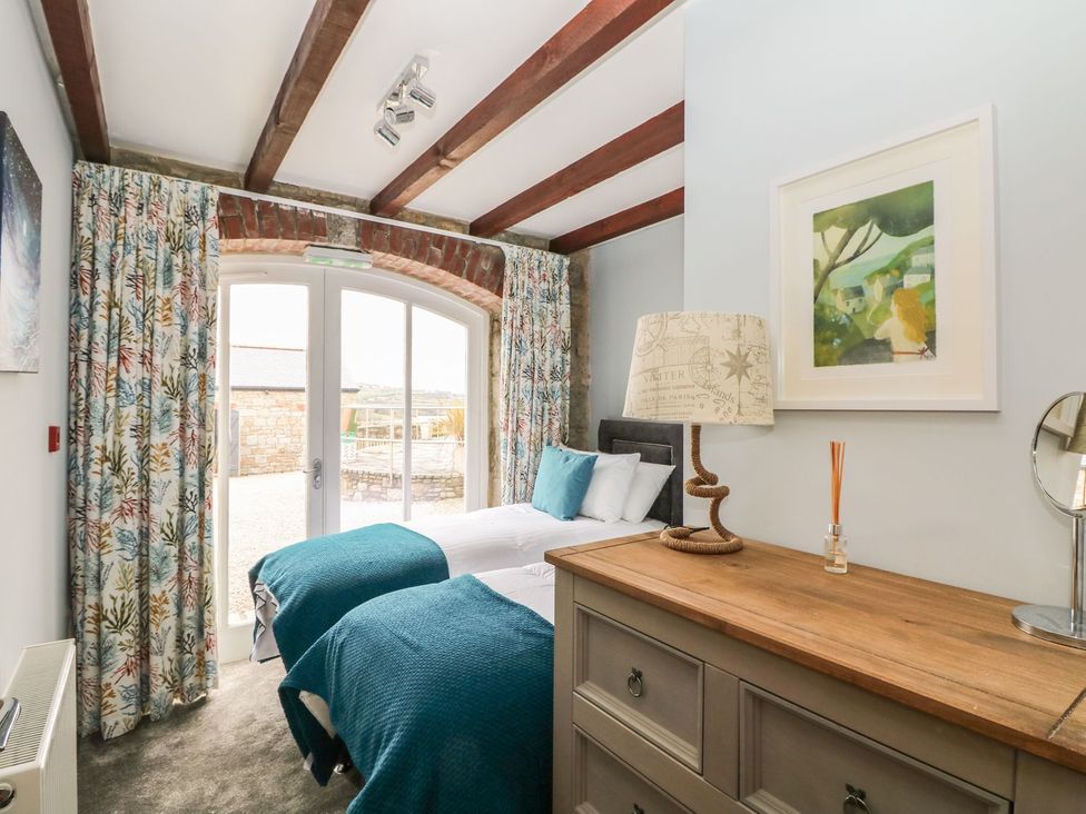 A bedroom with two beds and a wooden dresser at Helford in Treverva near Constantine