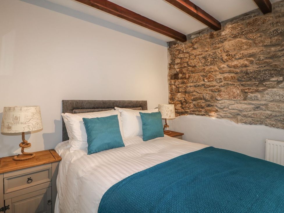 A bedroom with a bed and bedside lamps at Helford in Treverva near Constantine
