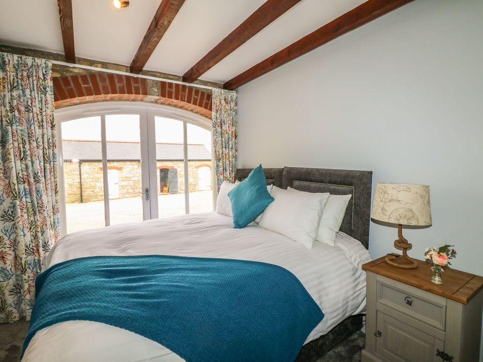 A bedroom with a bed and table lamp at Helford in Treverva near Constantine