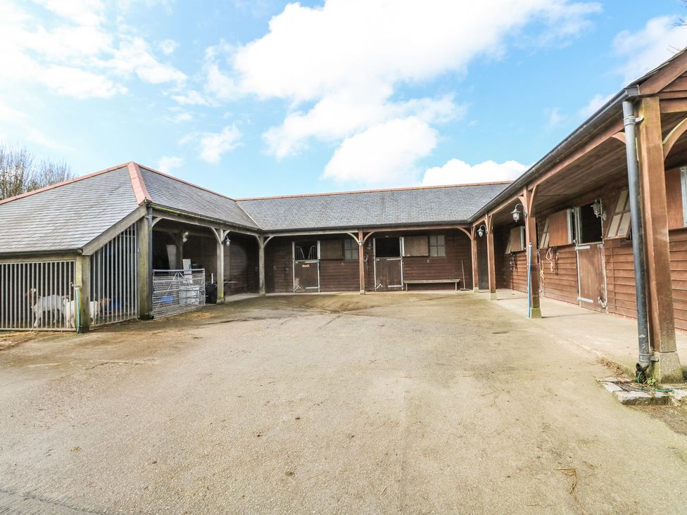 A stable area with horse stalls and a concrete floor at Helford in Treverva near Constantine