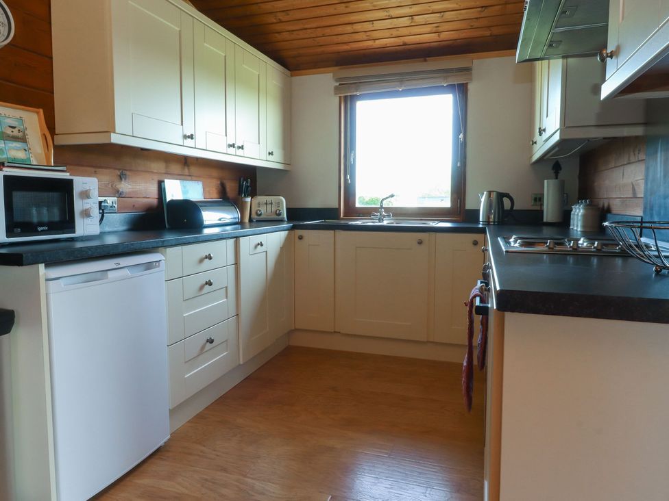 A kitchen with appliances and window at Chestnut Lodge in Pilling near Stake Pool