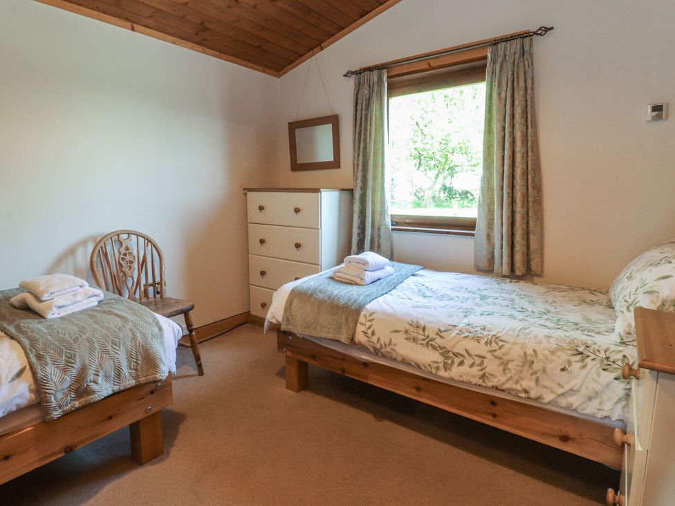 A bedroom with two beds and a window at Chestnut Lodge in Pilling near Stake Pool