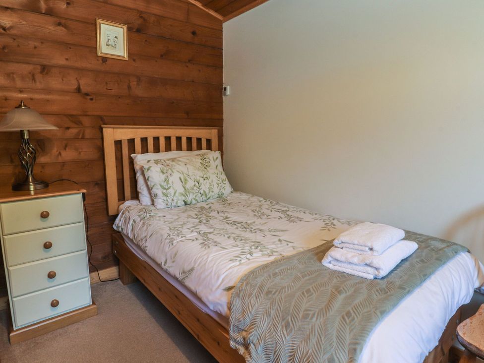 A bedroom with a bed and bedside table at Chestnut Lodge in Pilling near Stake Pool