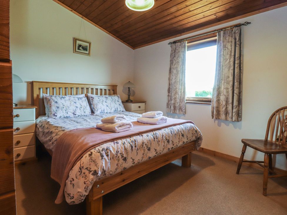 A bedroom with a bed and nightstand at Chestnut Lodge Pilling near Stake Pool