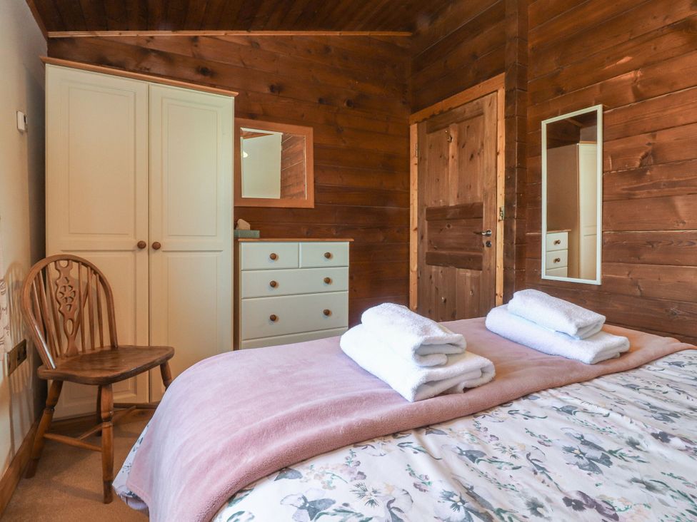 A bedroom with a bed and furniture at Chestnut Lodge in Pilling near Stake Pool