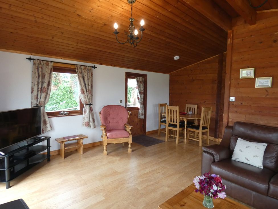 A living room with a television and dining area at Chestnut Lodge in Pilling