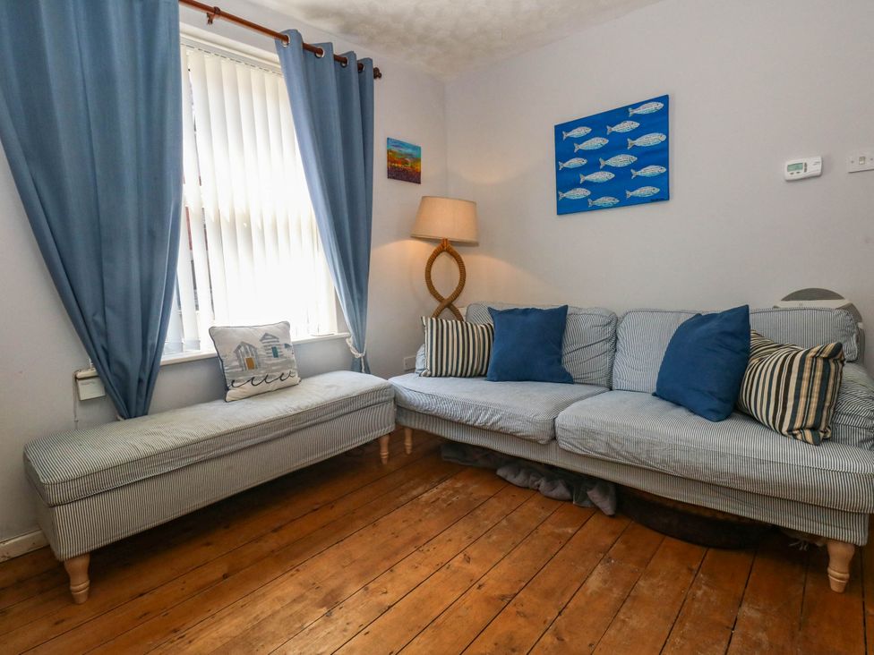 A living room with a sofa and lamp at Driftmark in Weymouth
