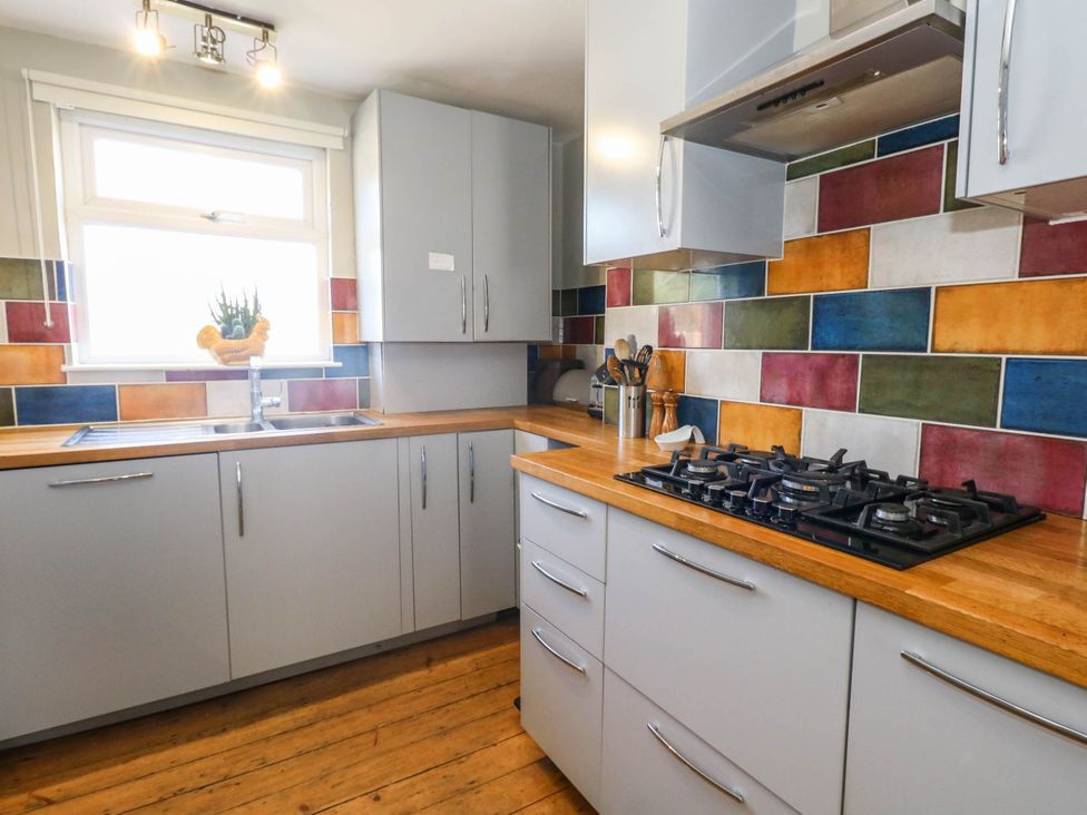 A kitchen with cabinets and a stove at Driftmark in Weymouth