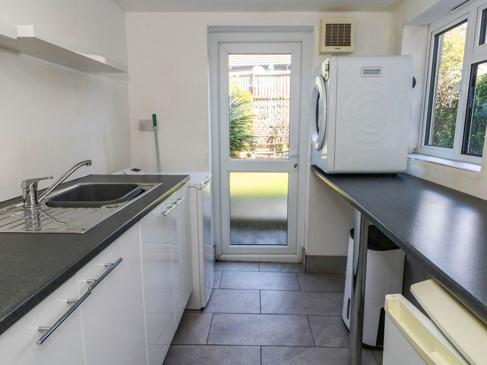 A utility room with a sink and washing machine at Driftmark in Weymouth