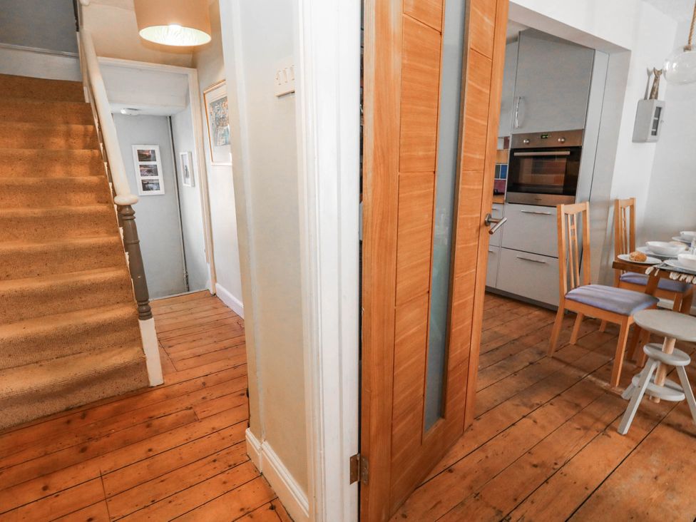 A hallway with a staircase and door leading to a kitchen at Driftmark in Weymouth