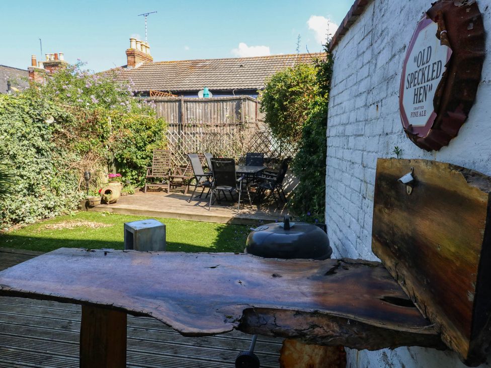 A garden with seating area and wooden table at Driftmark in Weymouth