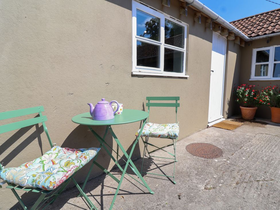 An outdoor seating area with a table and chairs at The Old Dairy Corsley near Warminster