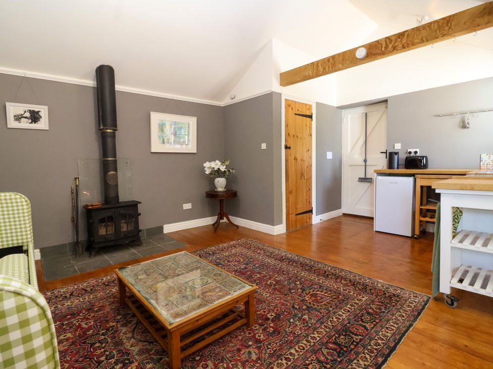 A snug with a stove and kitchenette area at The Old Dairy Corsley near Warminster