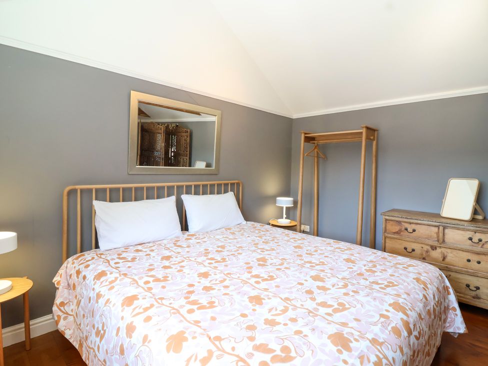 A bedroom with a bed and dresser at The Old Dairy Corsley near Warminster