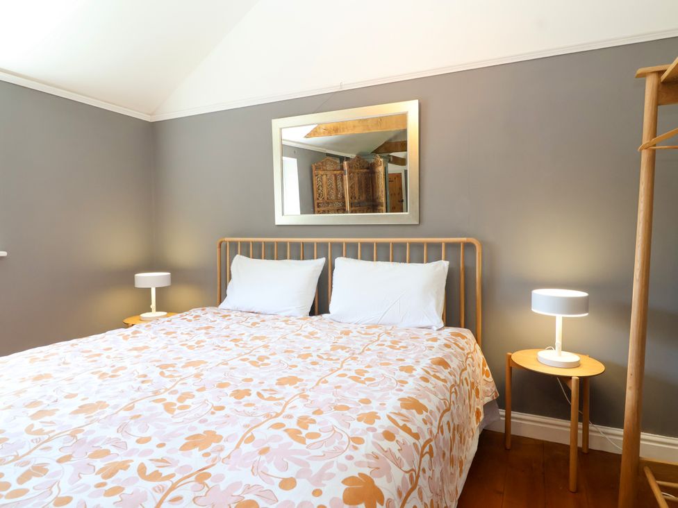 A bedroom with a bed and nightstands at The Old Dairy Corsley near Warminster