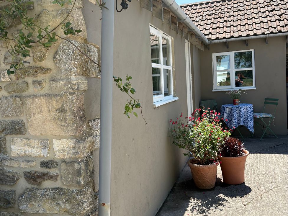 A garden area with a table and chairs at The Old Dairy Corsley near Warminster