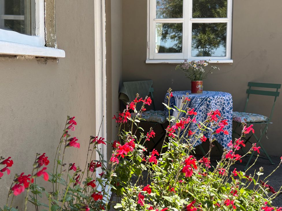 An outdoor seating area with a table and chairs at The Old Dairy in Corsley near Warminster