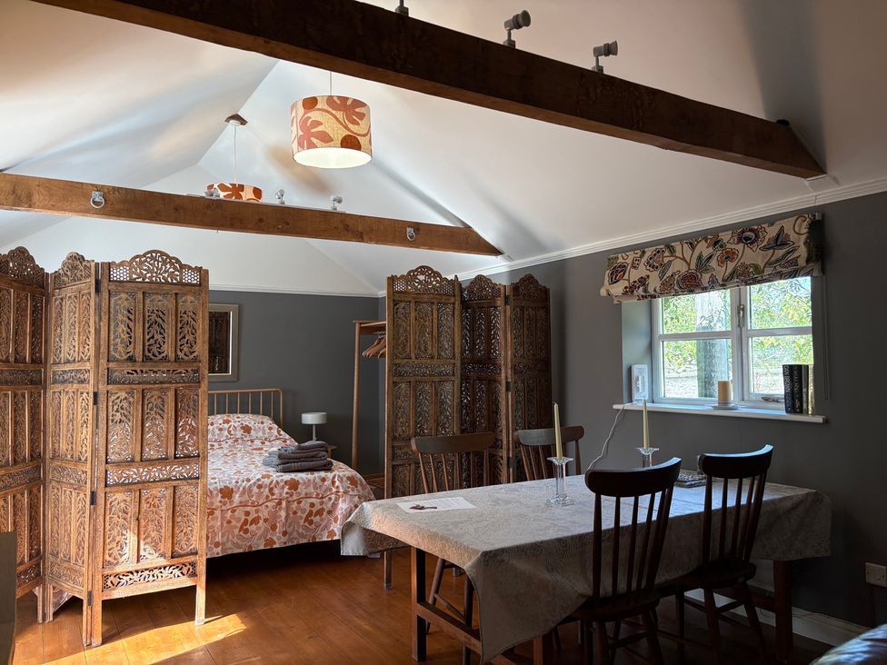 A bedroom with a bed and a dining table at The Old Dairy Corsley near Warminster