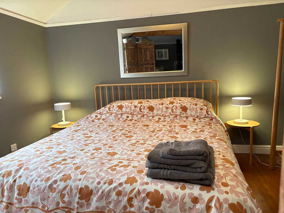 A bedroom with a bed and bedside tables at The Old Dairy in Corsley near Warminster