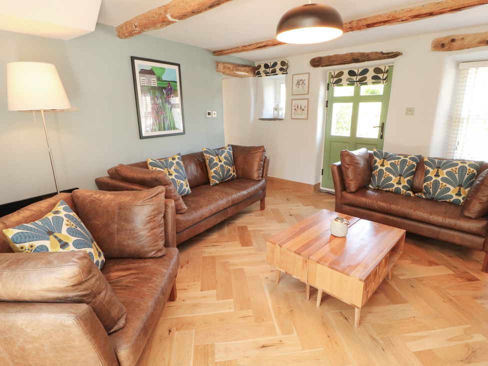 A living room with sofas and a coffee table at Haws Bank Cottage in Coniston