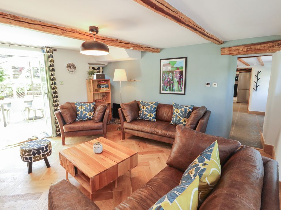 A living room with sofas and a coffee table at Haws Bank Cottage in Coniston