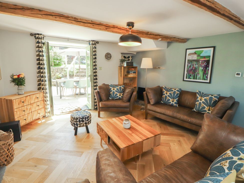 A living room with sofas and a coffee table at Haws Bank Cottage in Coniston