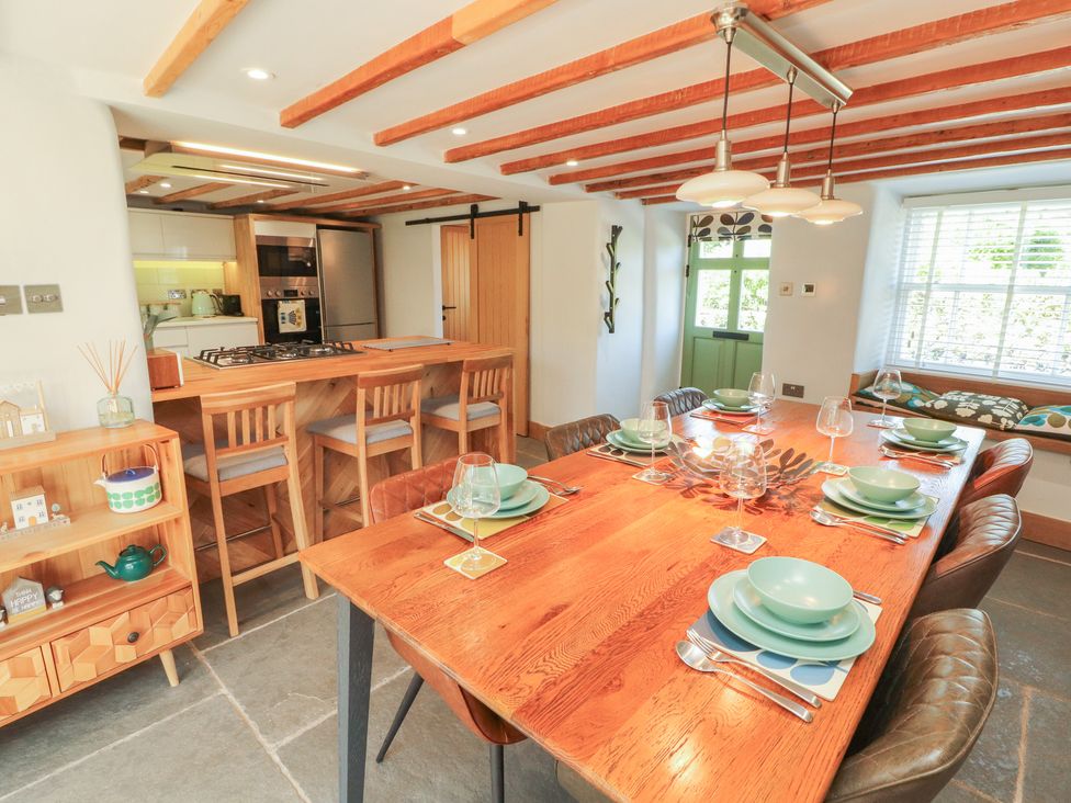 A dining room with a table set for dinner at Haws Bank Cottage in Coniston