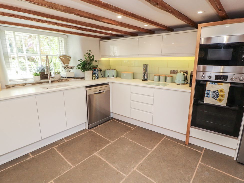 A kitchen with sink and appliances at Haws Bank Cottage in Coniston