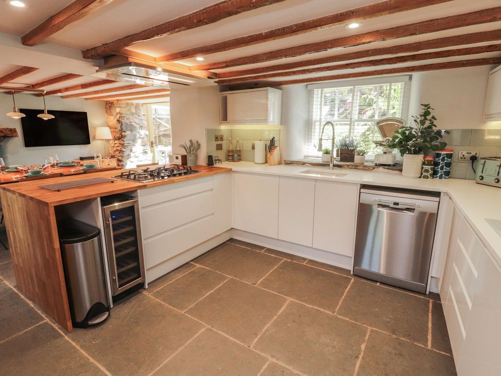 A kitchen with a gas stove and a wooden island at Haws Bank Cottage Coniston
