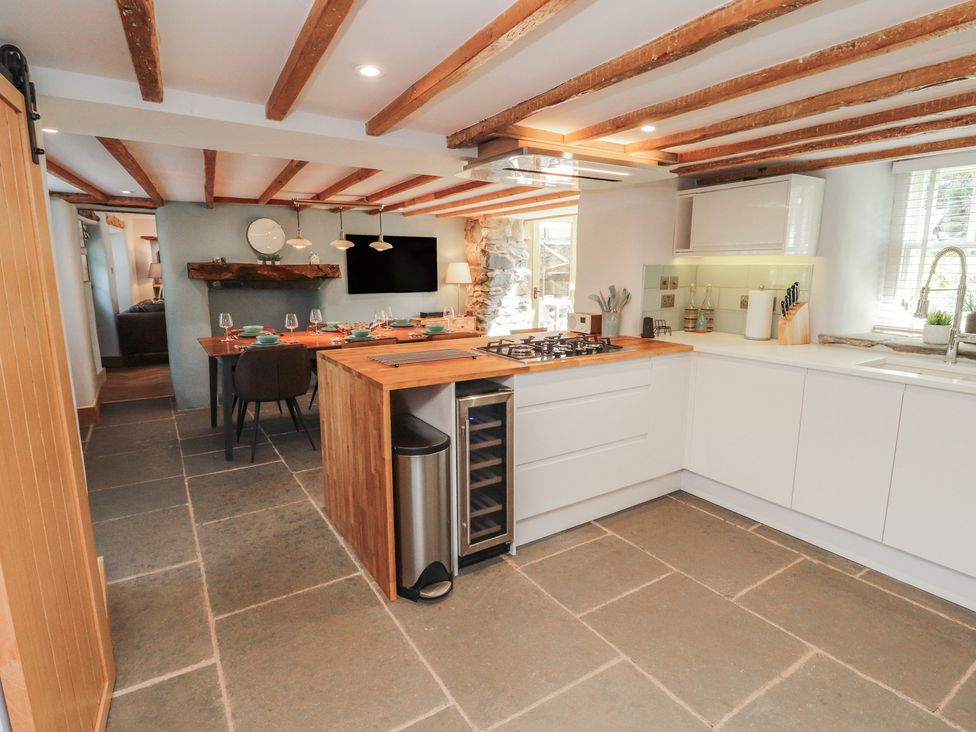 A kitchen with an island and dining area at Haws Bank Cottage in Coniston