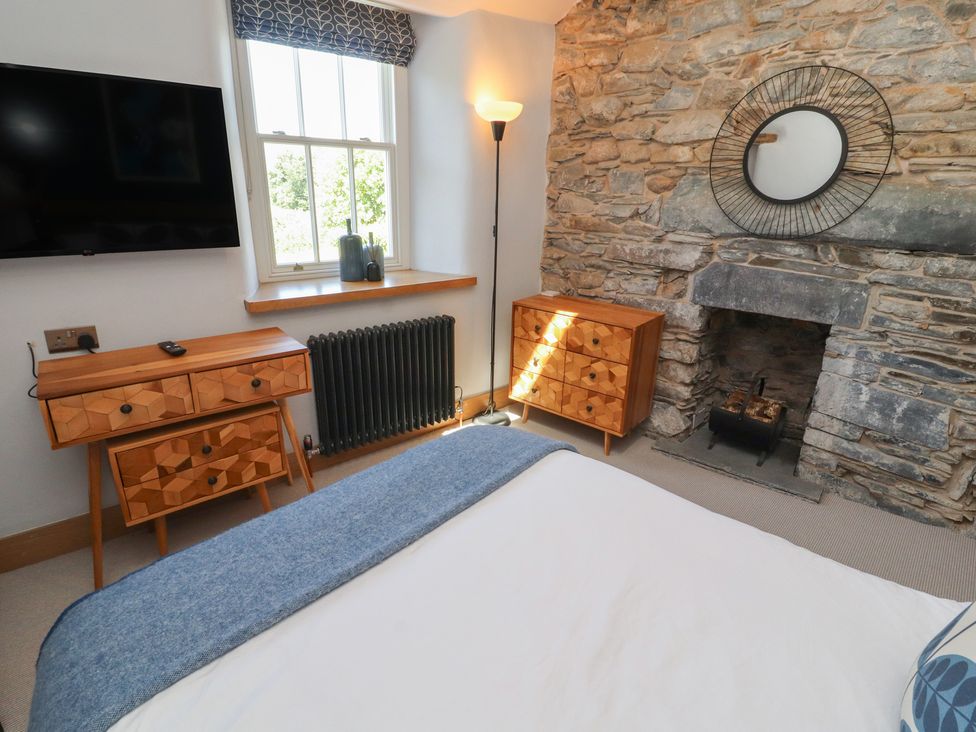 A bedroom with a television and dresser at Haws Bank Cottage in Coniston