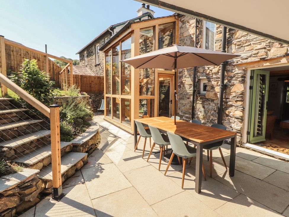 An outdoor dining area with a table and chairs at Haws Bank Cottage in Coniston