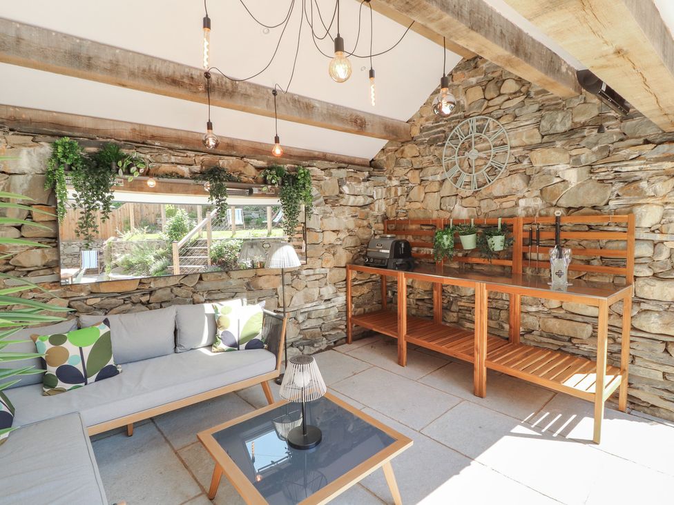 A conservatory with a sofa and table at Haws Bank Cottage in Coniston