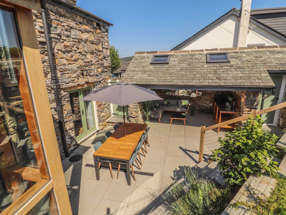An outdoor dining area with a table and umbrella at Haws Bank Cottage in Coniston